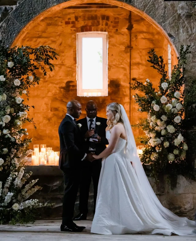 “Enjoy the day because it goes very quickly! We definitely had post-wedding blues once our wedding recovery had ended and all the celebrations were over – we just wanted to do it all again!” – @abbeyojamiren⁠
⁠
A ceremony led by family. A room full of love.⁠
⁠
Abbey and Josh’s wedding at Provenance Wines was thoughtful, elegant, and full of joy!⁠
⁠
Now live on Polka Dot Featured – link in bio.⁠
⁠
Photographer: @monikaberry_weddings / Venue: @provenance_wines / Bride's Dress: @georgiayoungcouture / Ceremony Musicians: @soundsofselah / Engagement Ring: @charlesrosejewellers / Groom & Groomsmen Attire: @formal_red / Flowers: @theposieplace / Hair & Makeup Artist: @emilymcgrathmakeupartist / Wedding Cake: @beatitfrostit / Gelato Van (dessert): @biancolattemelbourne / Videographer: @laestefilm⁠
⁠
[Image one description: Standing at their altar, an archway lit by candles and surrounded by white and green florals, this couple says their vows. The groom is wearing a classic black suit, and the bride is wearing a white one-shoulder draping gown with a long veil.⁠
⁠
Image two description: This is a closer look at the couple, taken over the shoulder of the groom. The star of this shot is the beaming smile on the bride's face.⁠
⁠
Image three description: An even closer look at the floral pieces at the altar, full of white roses and greenery. With pillar candles in glass jars in the background.]⁠
⁠
⁠
#PolkaDotWedding #FeelGoodWeddings #AustralianWeddings #AustralianWedding #WeddingStory #WeddingStories #WeddingMemories #WeddingInspiration #WeddingInspo #RealWedding #TimelessWedding #ProvenanceWinesWedding