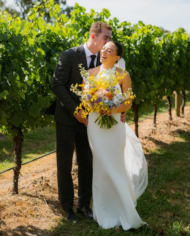 “Make sure you enjoy every part of the process. It is the best day of your life, so make it the best chapter!!” – @scarlett.faulkner ⁠
⁠
Scarlett and Riley skipped the "rules" and made their own – from getting ready together in an Airbnb with all their favourite people, to doing portraits pre-ceremony together.⁠
⁠
Add in vibrant florals by @flowers_by_megan, a ripper sunset, and @zonzoestate's famous Zoncello, and you've got a day that's pure sunshine!⁠
⁠
Photographer: @colcheedasphotography / Ceremony Musicians: @Wearepaperhearts / Flowers: @flowers_by_megan / MC: @melebrate_good_times / Ceremony Officiant: @melebrate_good_times / Content Creator: @maymarketingagency / Accessories: @kirstinash / Alterations: @alterationsbyemily.melb / Bride's Dress: @madewithlovebridal / Bridesmaid Dresses: @billy_j_boutique / Venue: @zonzoestate / Engagement Ring: @cullenjewellery / Groom's Attire: @menzmode / Hairstylist: @hairbyamandaaudrey / Makeup Artist: @sophiecampbellmakeup⁠
⁠
[Image one description: Embracing in a vineyard, this pair of newlyweds are enjoying the sun. The groom is in a classic suit with a subtle grey pattern, while the bride is in a silky, white halterneck gown. She's holding a vibrant bouquet full of blue, orange and yellow florals.⁠
⁠
Image two description: A shot of the bridesmaids at the ceremony, wearing silky champagne dresses in various cuts. Each bridesmaid holds a miniature version of the bride's bouquet in the same yellow and blue tones.⁠
⁠
Image three description: Basking in the sunset glow, the couple are kissing. Behind them the hills of vinyeyard are cast in shadow, as the sun only reaches the area they're standing.]⁠
⁠
⁠
#PolkaDotWedding #FeelGoodWeddings #AustralianWeddings #AustralianWedding #WeddingStory #WeddingStories #Zoncello #WineryWedding #SunshineWedding #WeddingMemories #WeddingInspiration #WeddingInspo #RealWedding